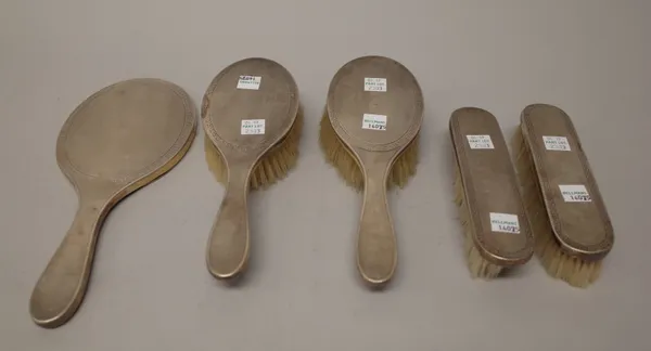 A lady's silver mounted five piece part dressing set, comprising; a hand mirror, two clothes brushes and two hairbrushes, each with engine turned deco
