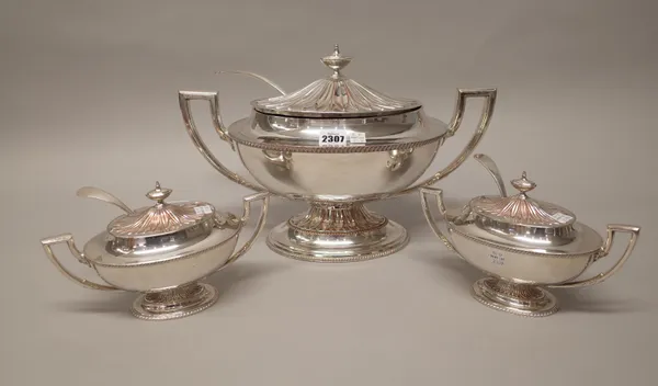 A plated on copper twin handled lidded soup tureen and a matching pair of smaller plated on copper twin handled lidded sauce tureens, each decorated w