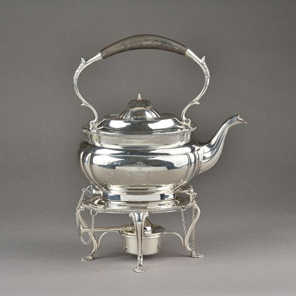 A silver spirit kettle, stand and spirit burner, the kettle of shaped oval form with a wooden handle and finial to the hinged lid, the stand raised on