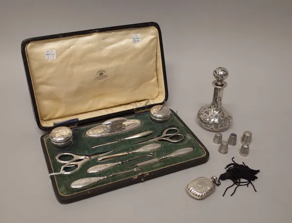 A silver mounted lady's manicure set, including, two glass jars, a nail buffer and various implements, one pair of scissors missing and with a base me