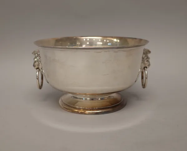 A silver twin handled centrepiece bowl, of circular form, with lion mask and ring handles, below a reeded rim, raised on a circular foot, London 1908,