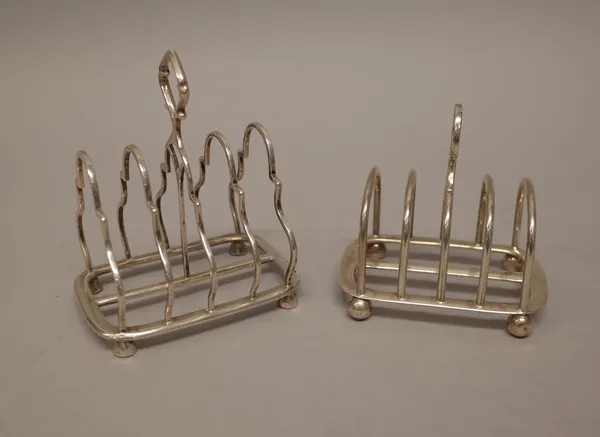 A silver five bar toastrack, of arched Gothic form, raised on four faceted feet and with a loop shaped handle, London 1919 and another silver five bar
