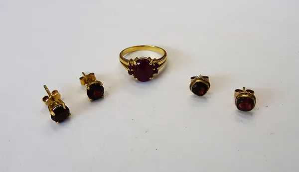 A gold and garnet ring, mounted with an oval carbuncle garnet to the centre, between two pairs of circular cut garnets and two pairs of gold and garne