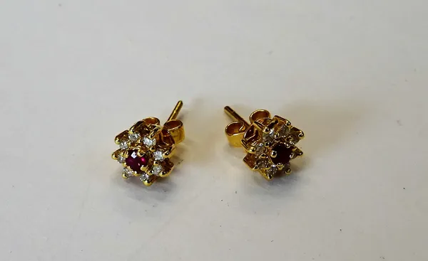 A pair of gold, ruby and diamond nine stone cluster earstuds, each claw set with the circular cut ruby to the centre, in a surround of eight circular