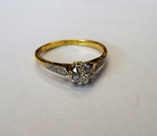 A gold and platinum, diamond set ring, mounted with the principle cushion shaped diamond to the centre, between diamond three stone shoulders, ring si