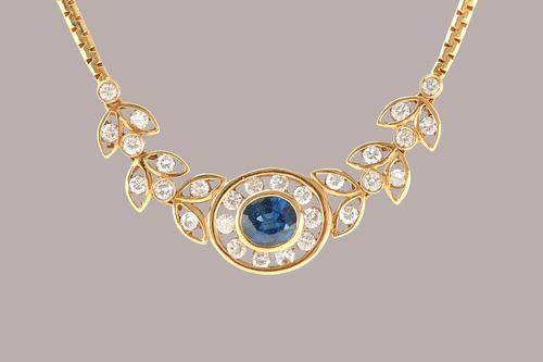 A gold, sapphire and diamond necklace, the front collet set with the oval cut sapphire at the centre, in a surround of circular cut diamonds, between