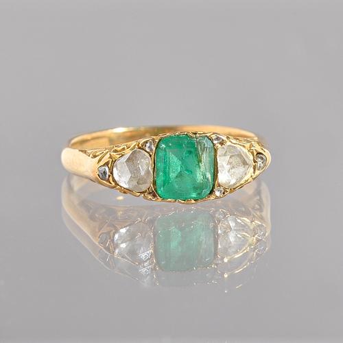 A gold, emerald and diamond ring, mounted with the square cut emerald to the centre, between the two principle rose cut diamonds and with five further