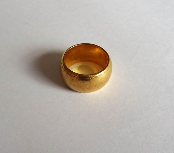 A gold wide band wedding ring, with traces of engraved decoration, detailed 22 CT, ring size K, weight 17.8 gms.