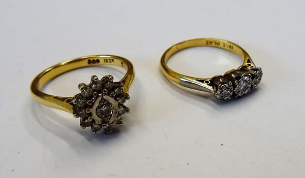 A gold and platinum, diamond set three stone ring, mounted with a row of circular cut diamonds and with the principal diamond mounted at the centre, d