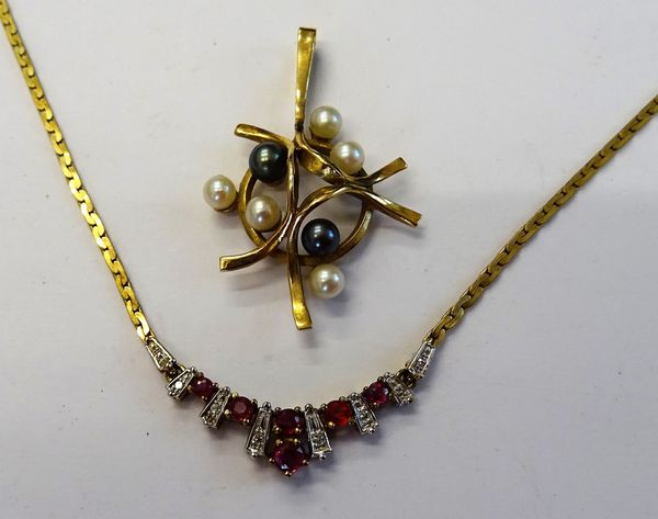 A 9ct gold, ruby and diamond set necklace, the front with a fanned motif, mounted with circular cut rubies and with small circular cut diamonds (one r