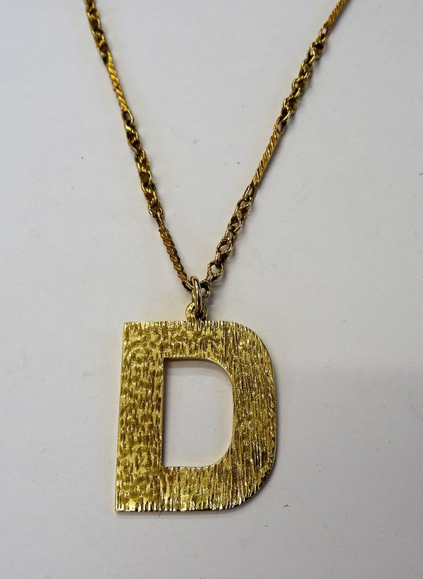 A gold pendant, designed as the initial D, having a bark textured finish, presentation inscribed and detailed 9 CT, with a gold twisted bar and multip