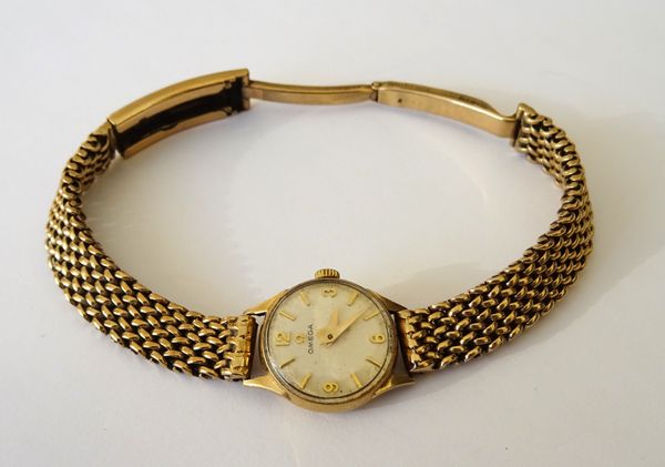 An Omega 9ct gold, circular cased lady's wristwatch, the signed silvered dial with gilt Arabic and baton shaped numerals, on a 9ct gold woven mesh lin