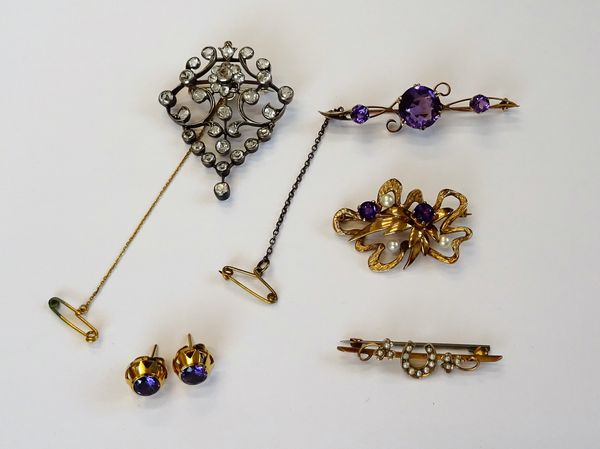 A gold and amethyst set three stone bar brooch, claw set with the principal circular cut amethyst to the centre, between two smaller circular cut amet