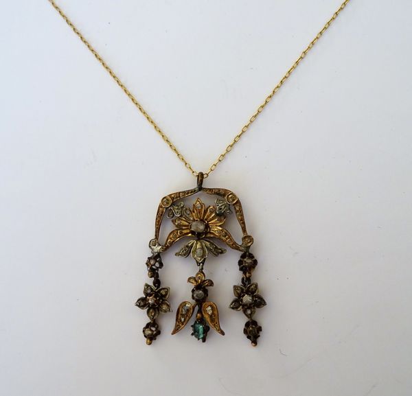 A diamond and emerald pendant, in a scroll and floral pierced design, mounted with rose cut diamonds, the front with three drops, with a gilt metal ov