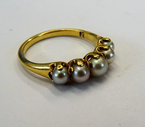 A gold ring mounted with a row of five cultured pearls, graduating in size to the centre, ring size L 1/2, gross weight 2.6 gms.