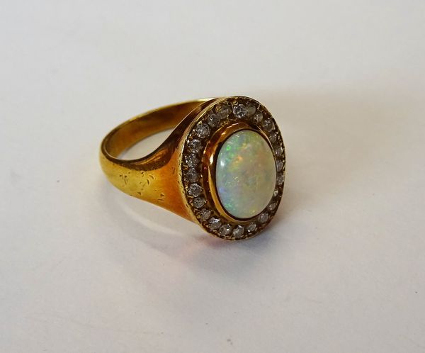 A gold, opal and diamond oval cluster ring, collet set with the oval opal in a surround of circular cut diamonds, detailed 18CT, ring size M, gross we