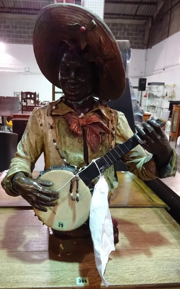 Plaster bust of an African American playing a banjo, 68cm high, (a.f.).
