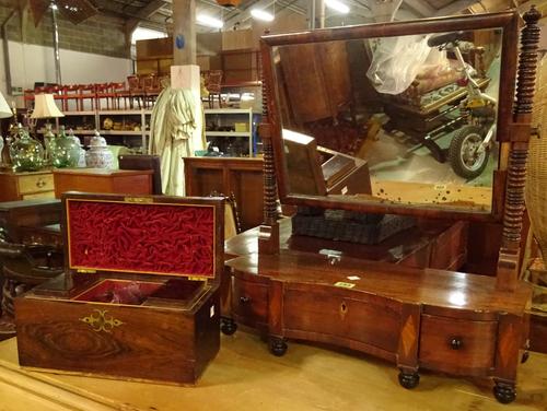 A 19th century mahogany serpentine dressing table mirror with three drawer base, 70cm wide and a 19th century rosewood tea caddy, (a.f) (2).