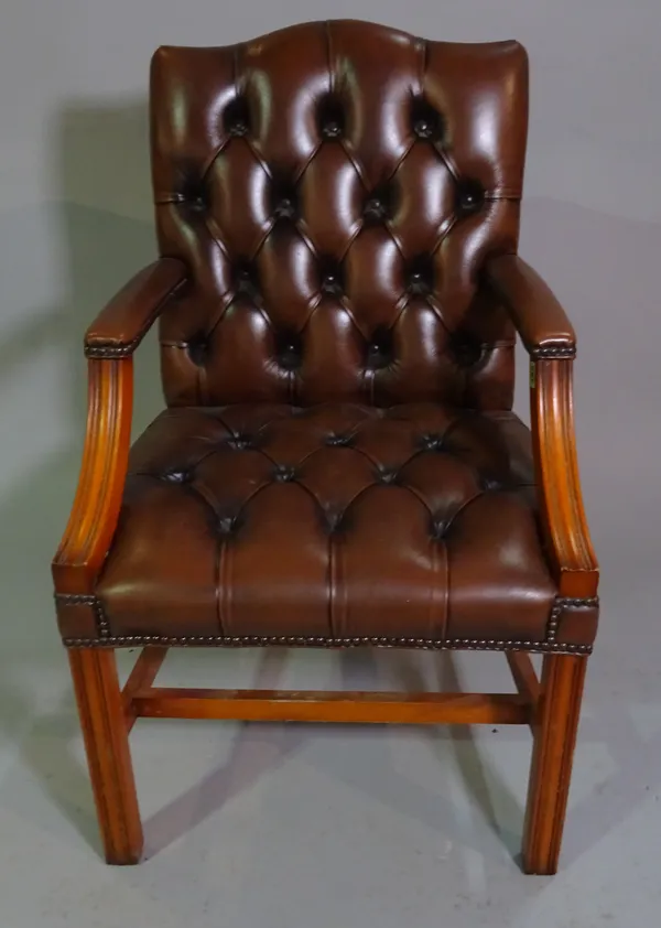 A George III style stained beech Gainsborough armchair with brown leather button back upholstery.