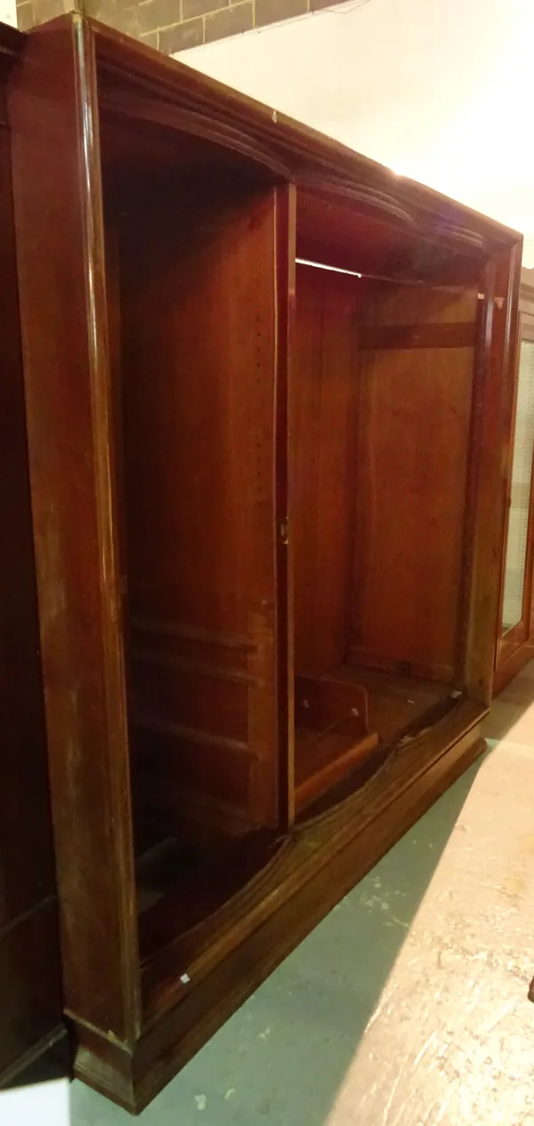 A 20th century mahogany bowfront triple door wardrobe, 235cm wide x 210cm high.