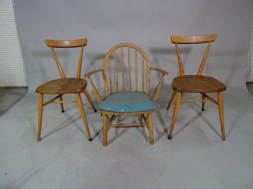 Ercol, a set of ten dining chairs with elm seats and beech backs and two similar Ercol open armchairs. (12)