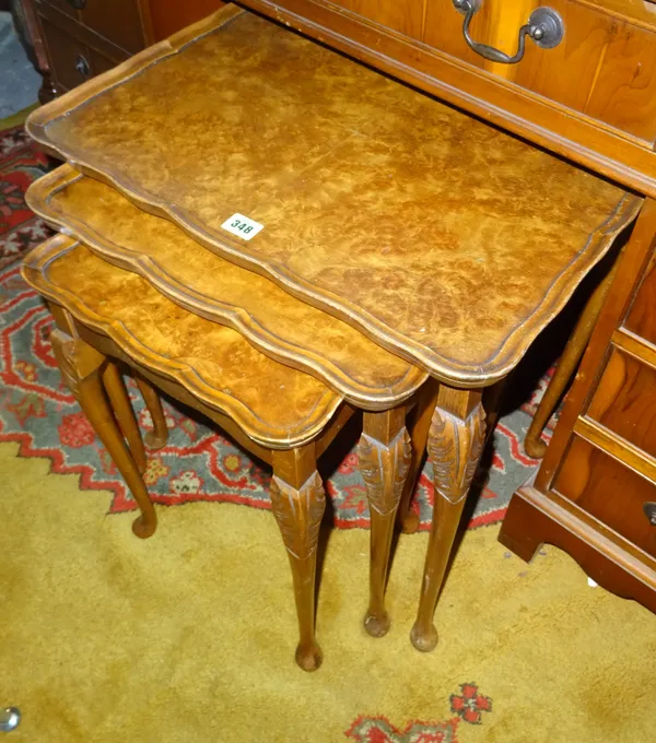 A nest of three 20th century walnut occasional tables, the larger 54cm wide x 56cm high, together with a pair of Regency mahogany dining chairs on sab