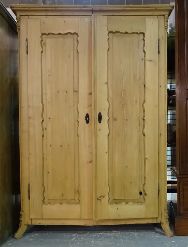 An early 20th century pine double wardrobe with panelled doors, 124cm wide x 177cm high.