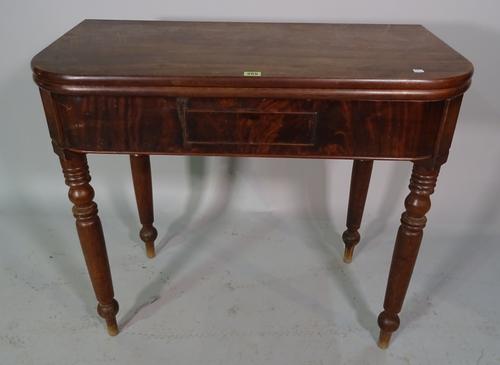 An early Victorian mahogany foldover tea table, on ring turned tapering supports, 89cm wide x 71cm high.