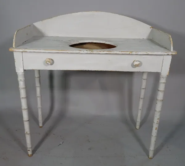 An early 20th century white painted washstand, the galleried top on faux bamboo tapering supports, 95cm wide x 97cm high.