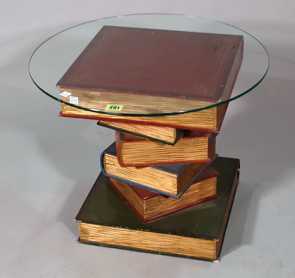 A 20th century glass side table, the base formed as a stack of faux books, 50cm wide x 42cm high.