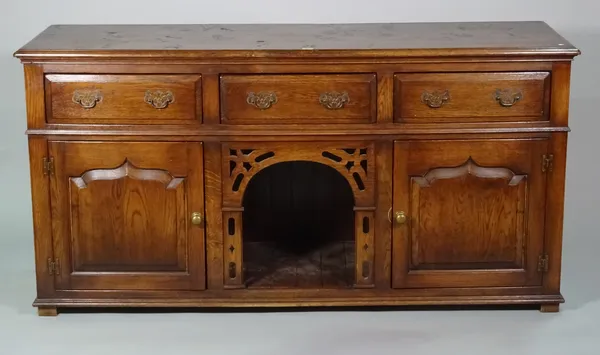 An 18th century style oak dresser base with three drawers over cupboard base, 165cm wide x 84cm high.