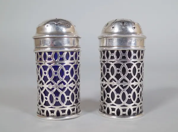 A pair of Edwardian/ Victorian silver and blue glass lined cruets, hallmarked for D*F, Birmingham, probably 1901, 6.5cm high, (2).