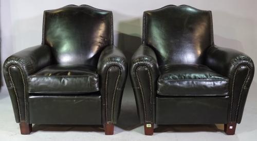 A pair of 20th century brass studded green leather upholstered easy armchairs on tapering block supports, 90cm wide x 100cm high.