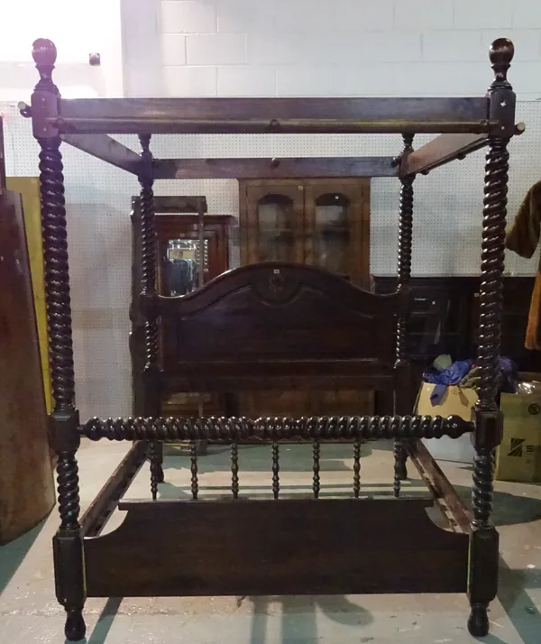 A 20th century stained pine four poster bed with spiral twisted supports.