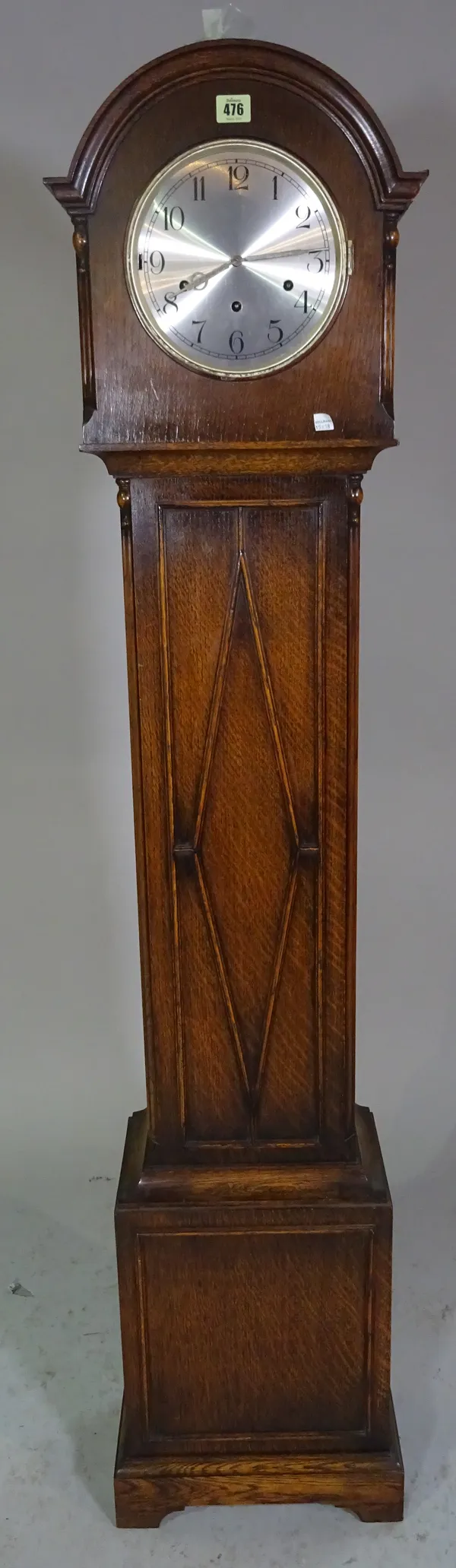 A 20th century oak cased grandmother clock with silvered dial, 2 weights & pendulum.