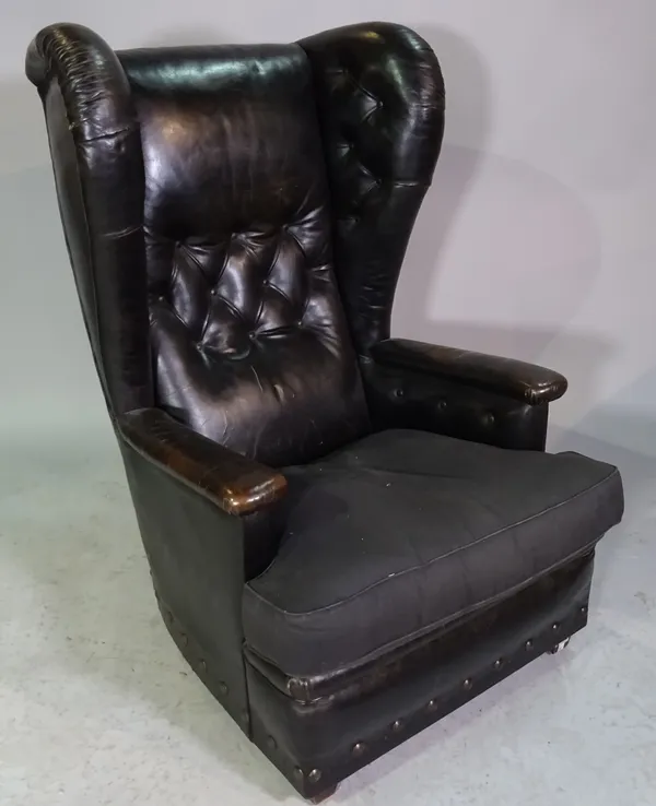 A mid-20th century black leather upholstered wingback armchair on squat block supports, 77cm wide x 116cm high.