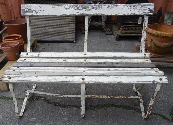 An early 20th century white painted strap iron garden bench, 107cm wide x 75cm high.