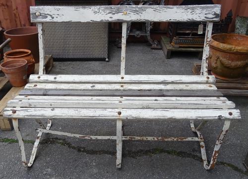 An early 20th century white painted strap iron garden bench, 107cm wide x 75cm high.