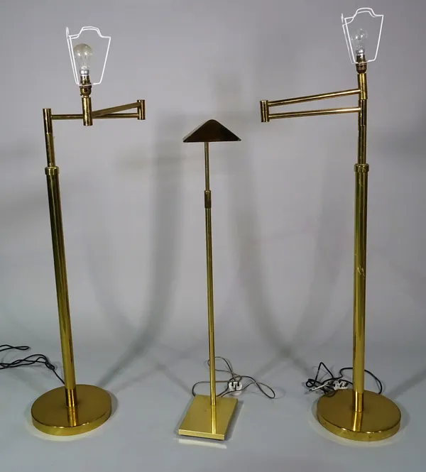 A pair of 20th century brass adjustable standard lamps, 130cm high and a 20th century brass reading light, 110cm high, (3).