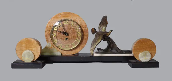 A mid-war three piece onyx mounted marble timepiece garniture, circular case with skeleton chapter ring, flanked by gilt metal figure of a tern above