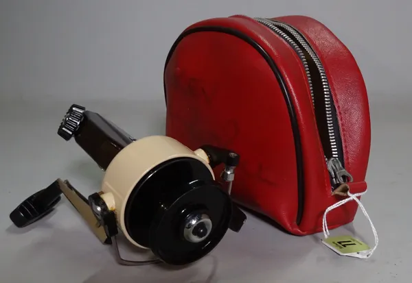 An 'Abu Cardinal 66X'  pike fishing reel in a red leather pouch.