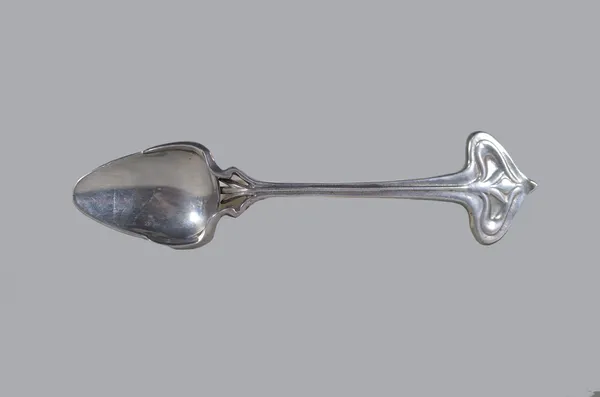 In the manner of Archibald Knox for Liberty & Co; a polished metal preserve spoon, apparently unmarked, 16.5cm high.