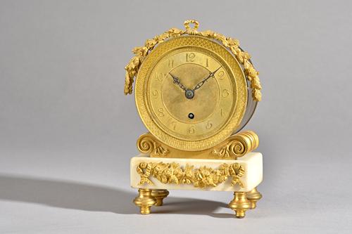 An Empire style ormolu and white marble mantel clock, late 19th century, with drum case over a marble plinth and four feet, 19cm high, (no key or pend