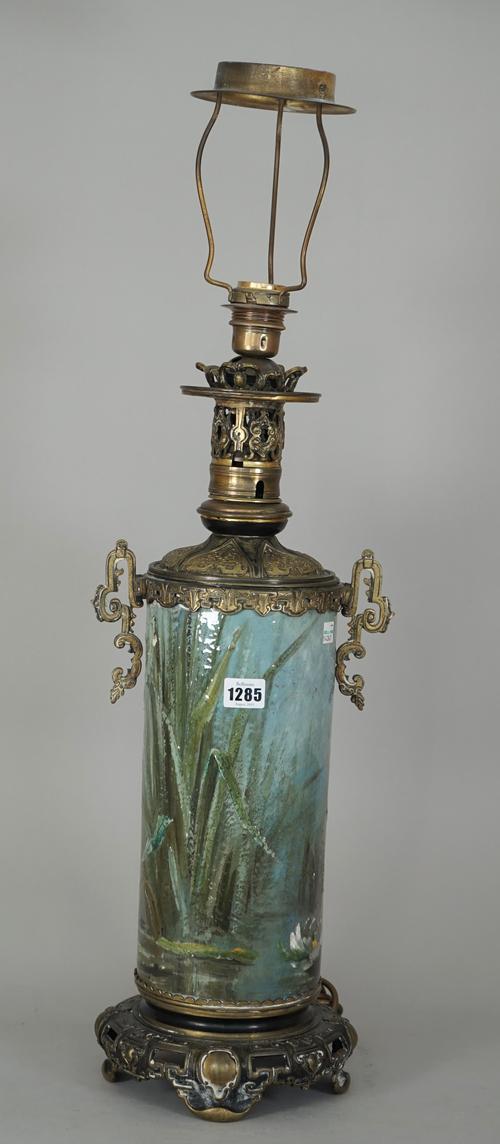 A pottery table lamp painted with dragonfly and water lily around a pond, enclosed in a pierced Chinese style gilt metal mount, 56cm high.