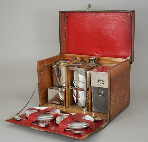 A mid-20th century leather cased picnic set, wooden lined fitted interior with porcelain tea cups and saucers, case 32cm wide.