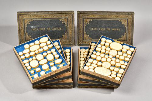 A quantity of plaster intaglios 'Casts From The Antique' housed in two cases, each comprising four trays (approx. 320 intaglios) each tray titled and
