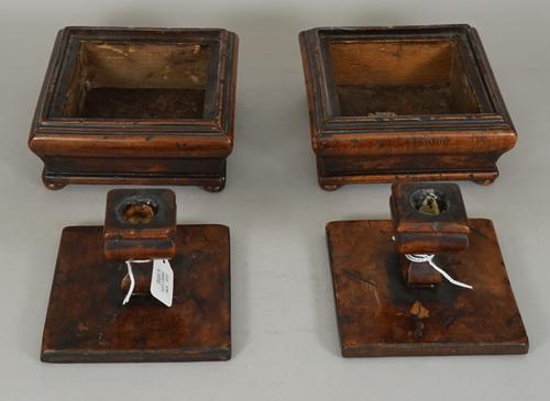 A pair of French fruitwood candlesticks, late 18th century/early 19th century, each of square form with removable lid, 15.5cm wide, and a pair of bras