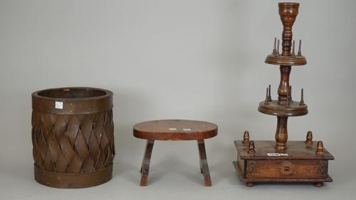 A 19th century stained pine sewing spool holder on a rectangular base with frieze drawer and candle sconce to the top, 46cm high, a small wooden foots