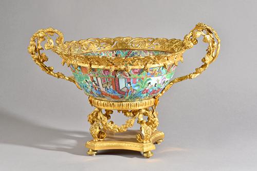 An ormolu mounted Cantonese porcelain bowl, late 19th century, the bowl decorated with Oriental figures enclosed in a two handled frame cast with frui