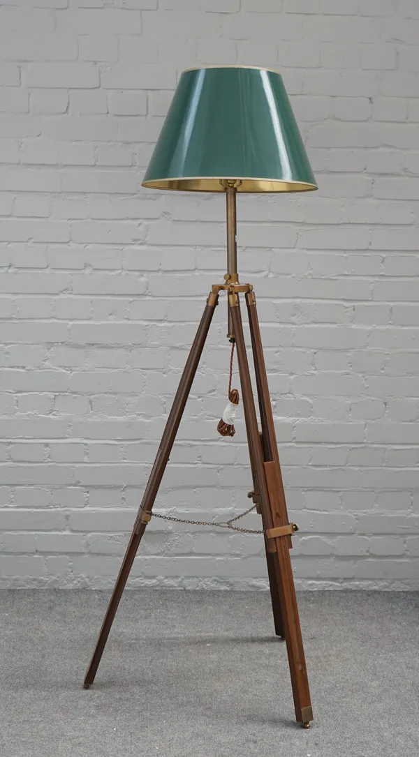 A mahogany and brass mounted tripod standard lamp with adjustable legs and green shade and a 17th century style carved walnut standard lamp on a trifo